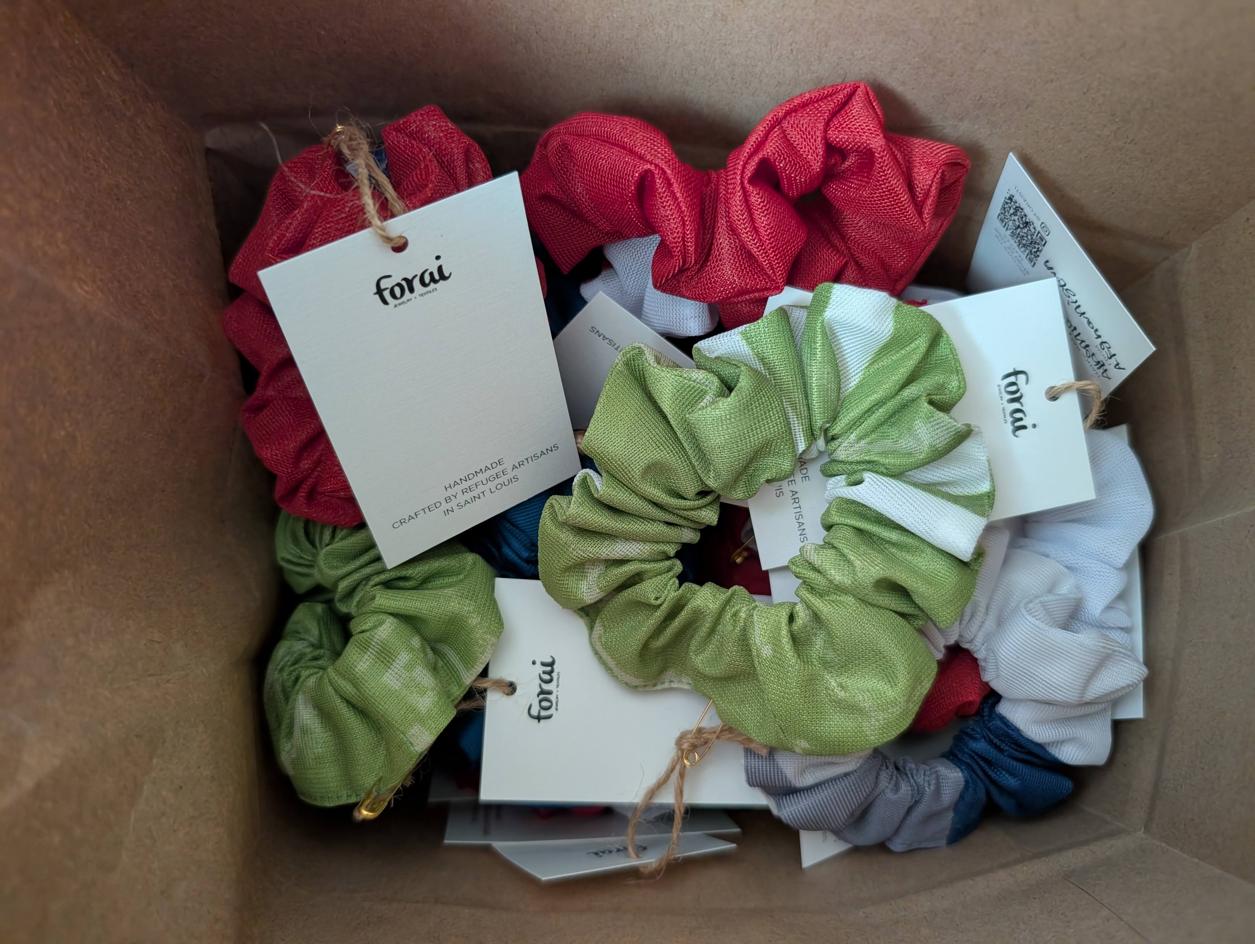 A box full of scrunchies made by Forai's seamstresses using polyester signage from Washington University in St. Louis and the 39 North AgTech Innovation District.