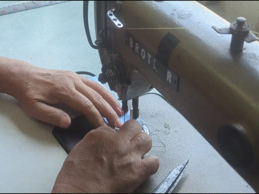 Seamstress in Thailand handmaking a Morph Bags product from event signage.