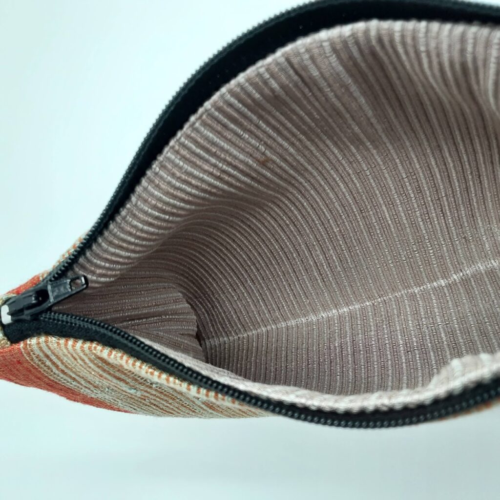 An orange and beige handmade Thai silk pouch made by an informal seamstress for Morph.