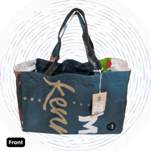 The front view of a one-of-a-kind dark green Market Bag with gold cursive script, white lettering, and colorful patterned side panels.