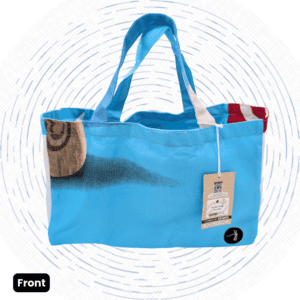 The front view of a one-of-a-kind bright turquoise Market Bag with a dark smudge print, a tan circular graphic, and red-and-white striped inner trim.